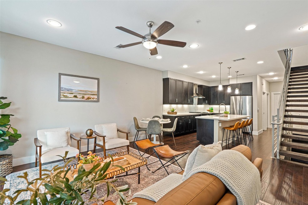 Living room featuring ceiling fan, dark wood fini