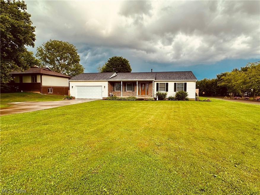 Ranch-style home featuring a garage and a front yard