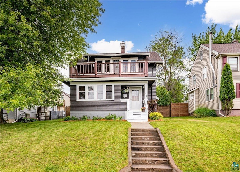 Front of property with a front lawn and a balcony