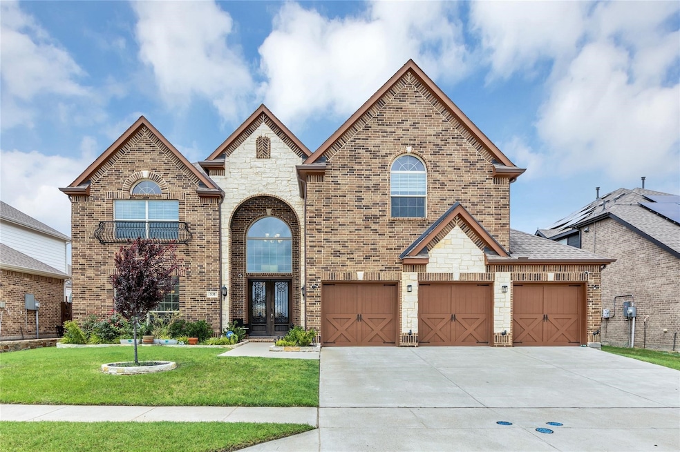 French country style house with brick siding, concrete driveway, a front lawn, and an attached garage