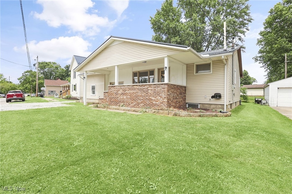 View of front facade featuring a front yard, brick siding, and driveway