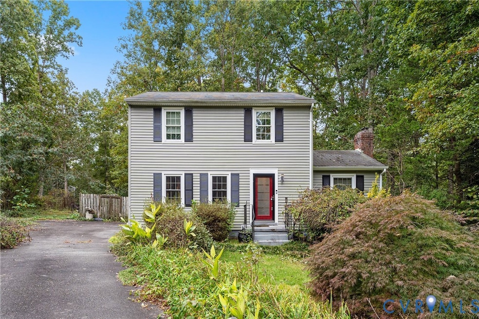 Colonial-style house with asphalt driveway