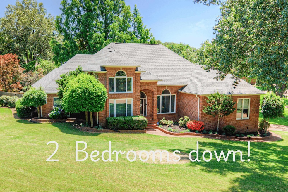 Traditional-style home featuring brick siding, a front yard, and roof with shingles