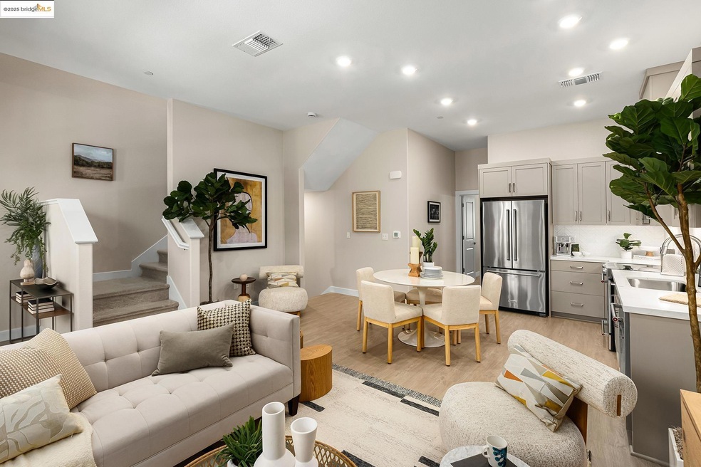 Living room featuring light wood-style flooring, recessed lighting, and stairway