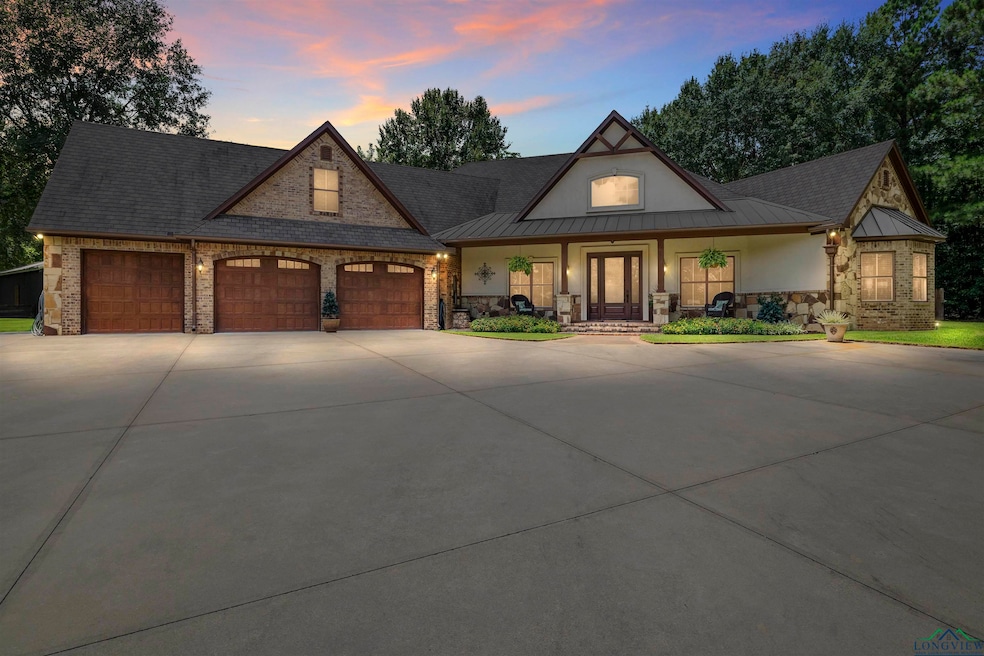 View of front facade featuring a porch, concrete driveway, stone siding, and an attached garage