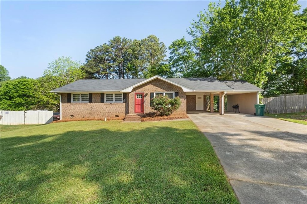 Ranch-style home with driveway, brick siding, and 