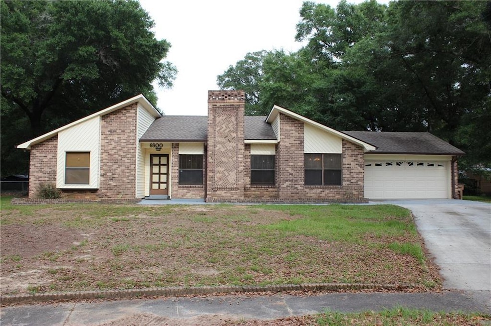 Modern inspired home with brick siding, an attached garage, concrete driveway, and a chimney