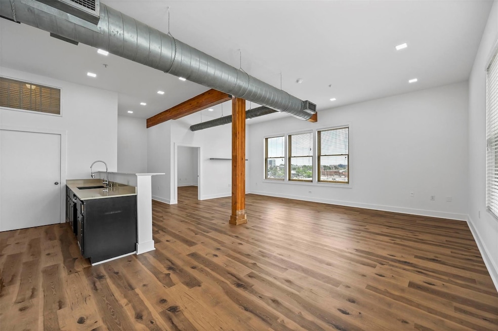 Unfurnished living room with beam ceiling, dark wo