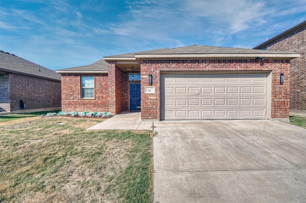 View of front facade with a garage and a front law