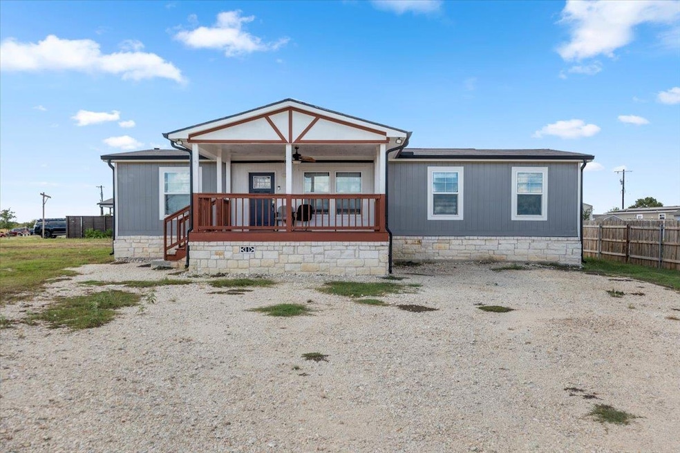 Rear view of house featuring a ceiling fan and covered porch