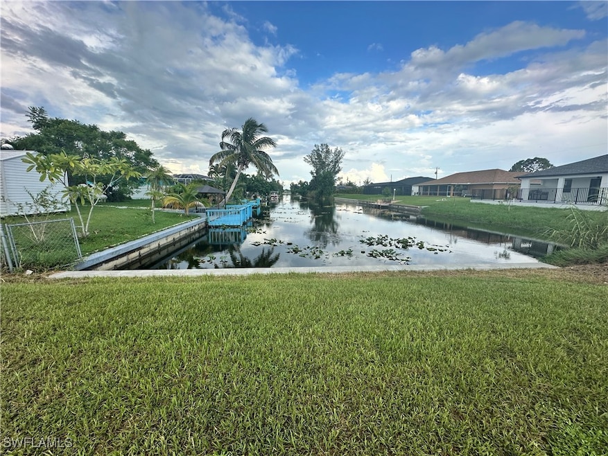 View of dock featuring a yard and a water view