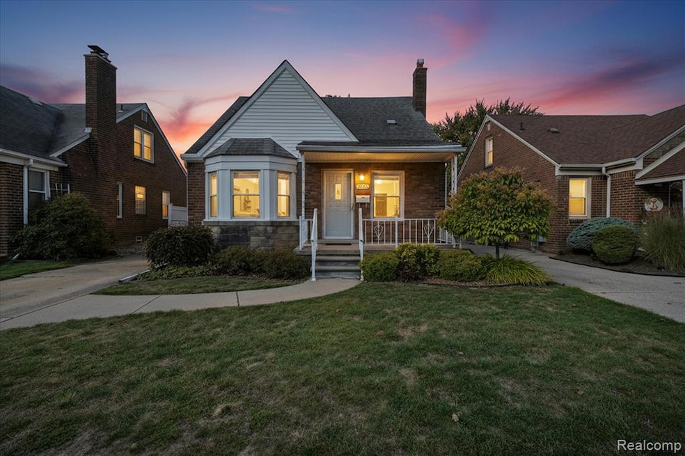 View of front facade with a front yard, a chimney, a porch, stone siding, and brick siding