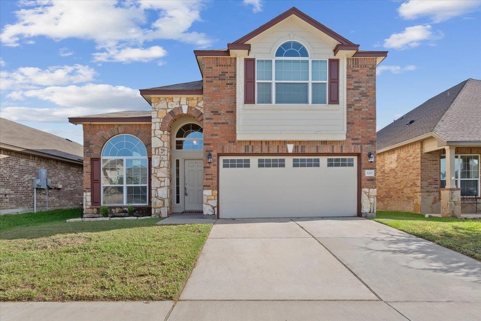 Traditional home with a garage, driveway, a front