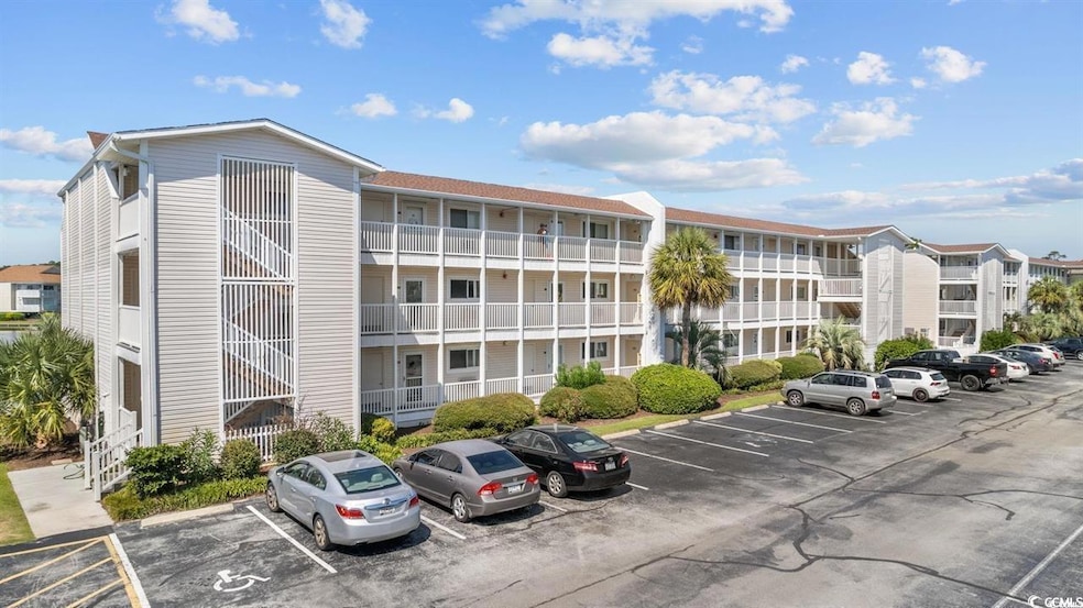 View of apartment building / complex featuring uncovered parking