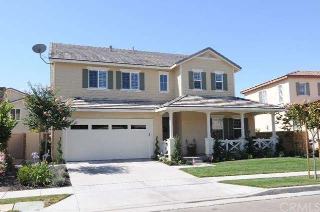 Front with lush landscaping and relaxing porch ent