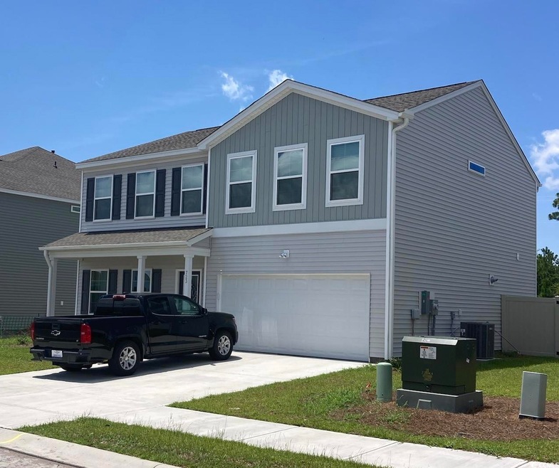 View of front facade with a garage and central AC unit