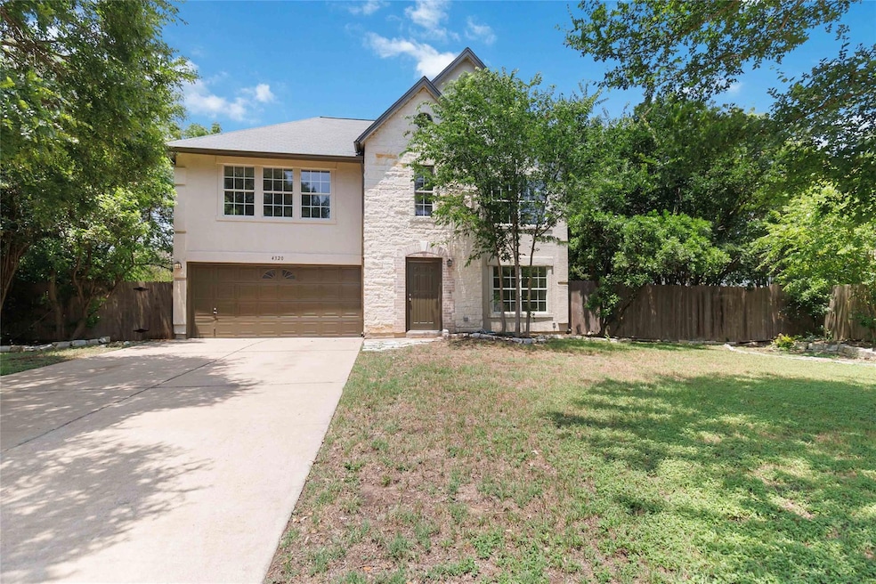 View of front facade featuring a garage, stone si
