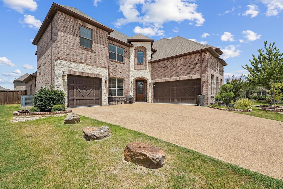 View of front facade with cooling unit, a garage, 