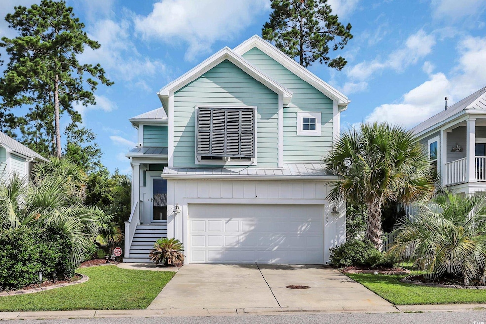 View of front of home featuring a garage, driveway, a standing seam roof, a metal roof, and stairs