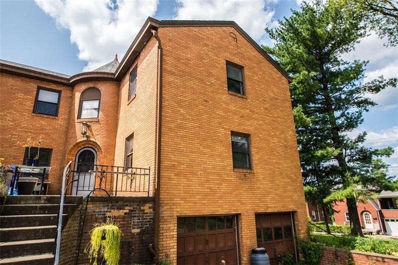 Exterior front shows curved entryway and 2 car gar