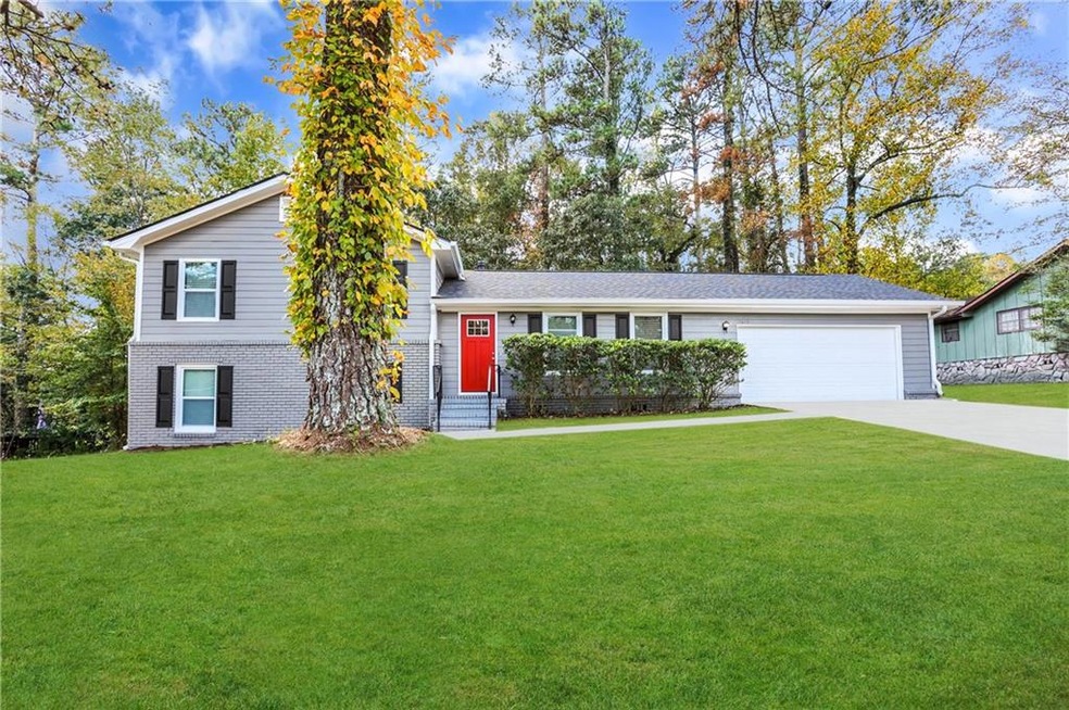 Tri-level home featuring a garage and a front yard