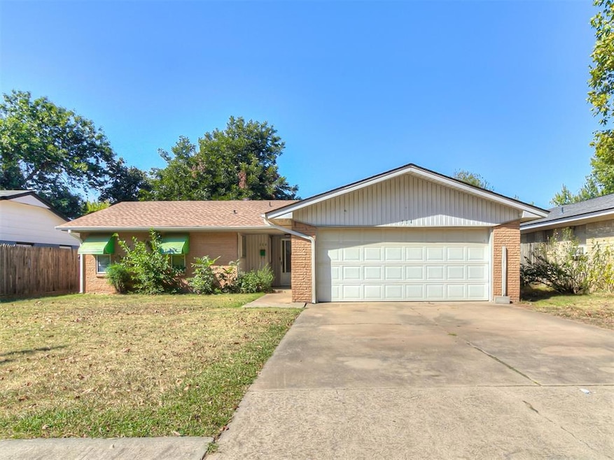 Ranch-style house featuring a front yard and a gar