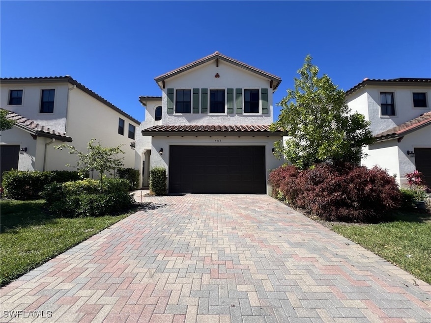 Mediterranean / spanish-style house featuring stucco siding, decorative driveway, an attached garage, and a tiled roof