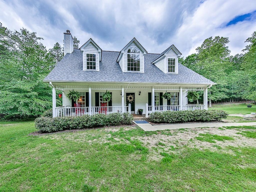 Cape cod-style house featuring roof with shingles, a porch, a front lawn, and a chimney