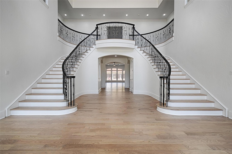 Foyer featuring wood finished floors, arched walkw
