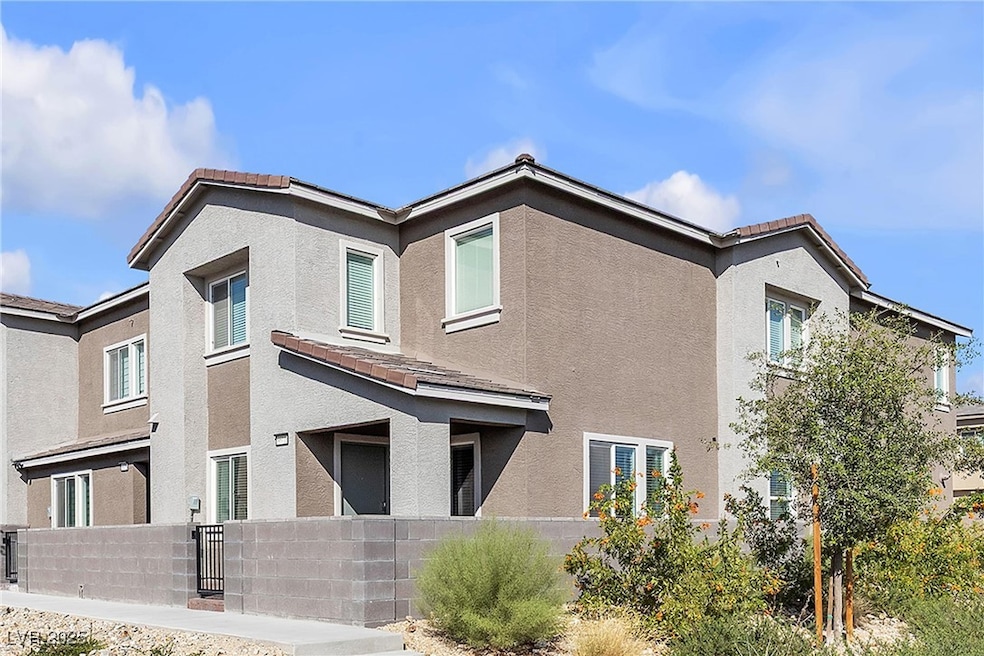 Back of house with a tile roof, stucco siding, and a fenced front yard