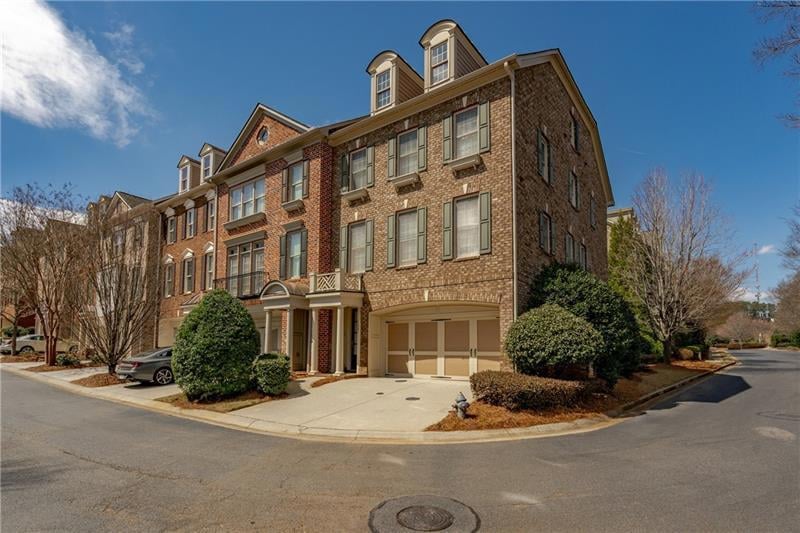 View of home with brick on front and side, two car
