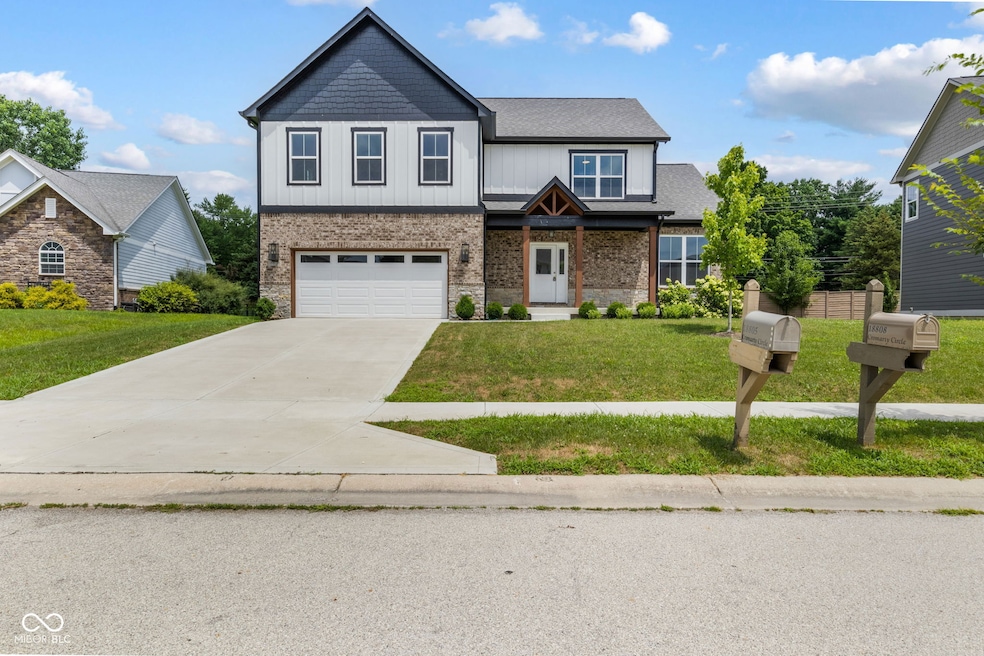 craftsman house with a front lawn, driveway, a garage, and brick siding
