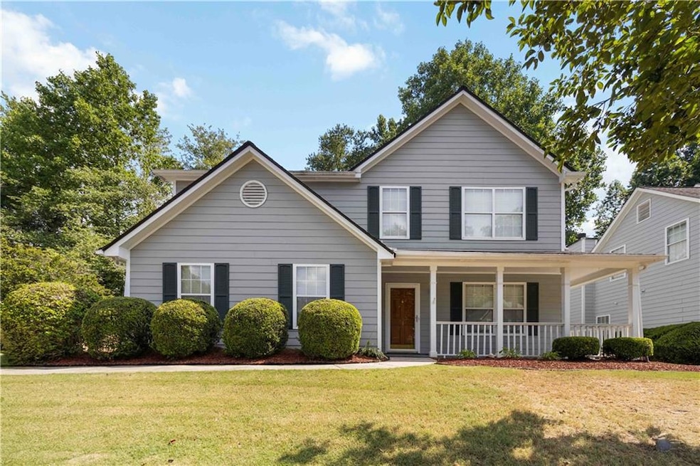 Traditional-style home with covered porch and a front lawn