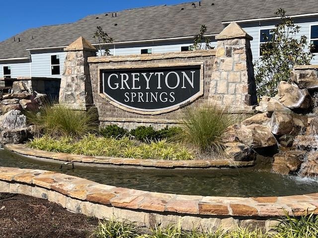 Community sign with a small pond