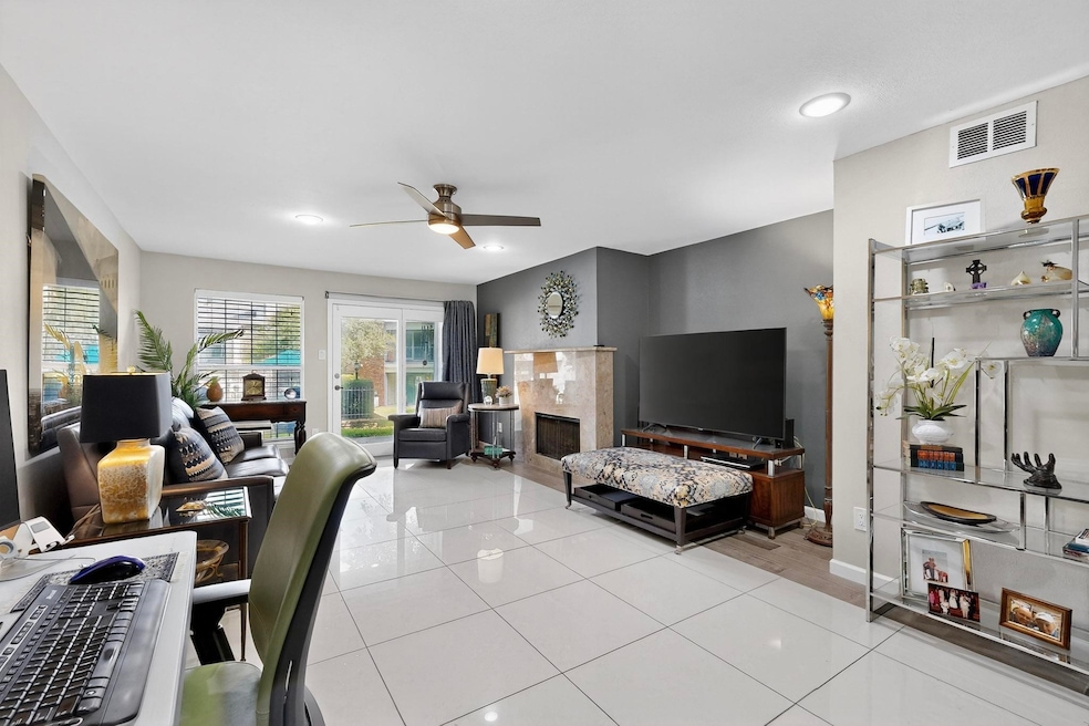 Living room featuring a fireplace, light tile patterned flooring, ceiling fan, and recessed lighting
