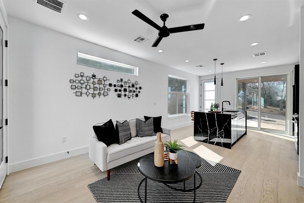 Living area featuring ceiling fan, light wood-sty