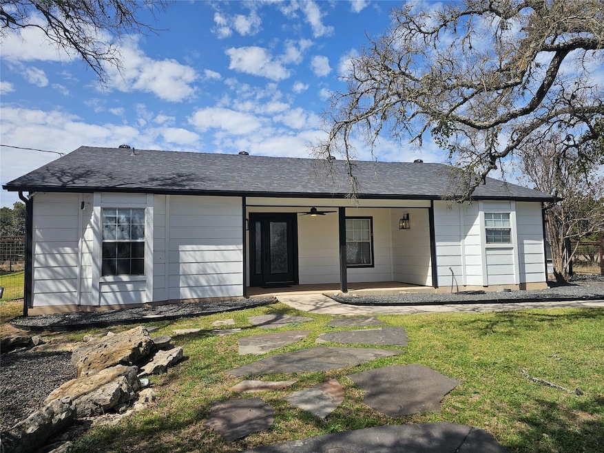 View of front of house with ceiling fan and a pat
