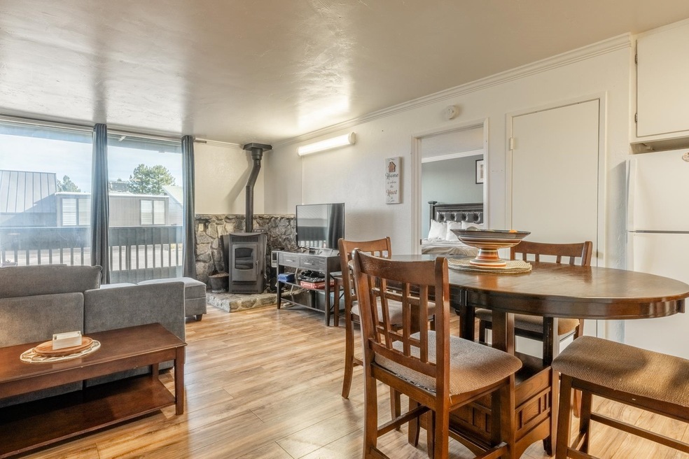 Dining area featuring a wood stove, light wood-style floors, and crown molding