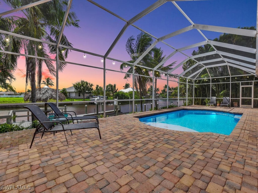 Pool at dusk featuring a patio, a water view, and