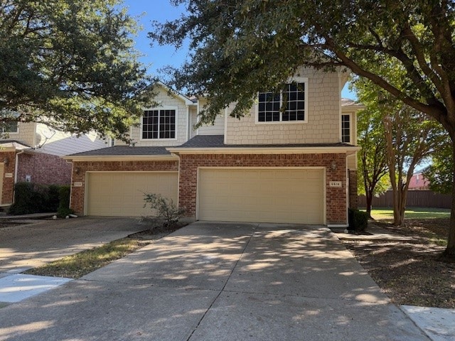View of front of property with concrete driveway and a garage