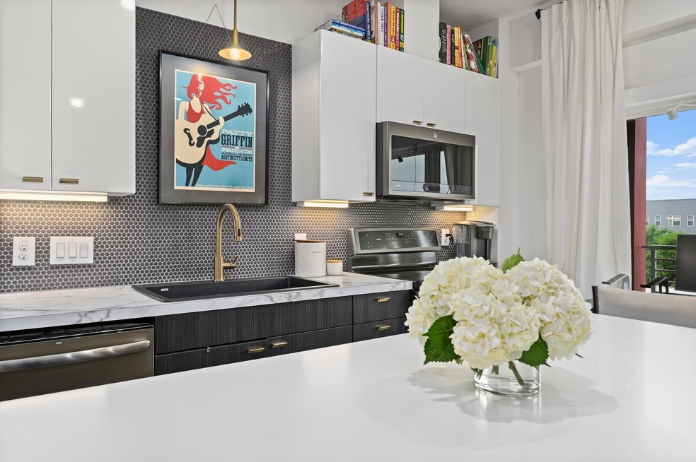 Kitchen featuring white cabinetry, appliances wit