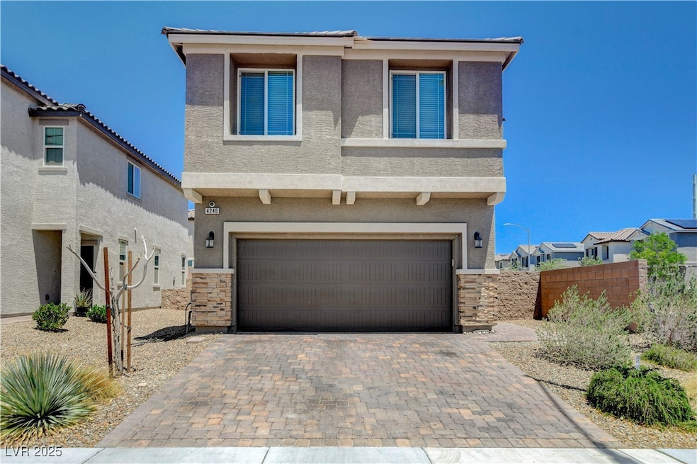 View of front facade with stucco siding, a garage,