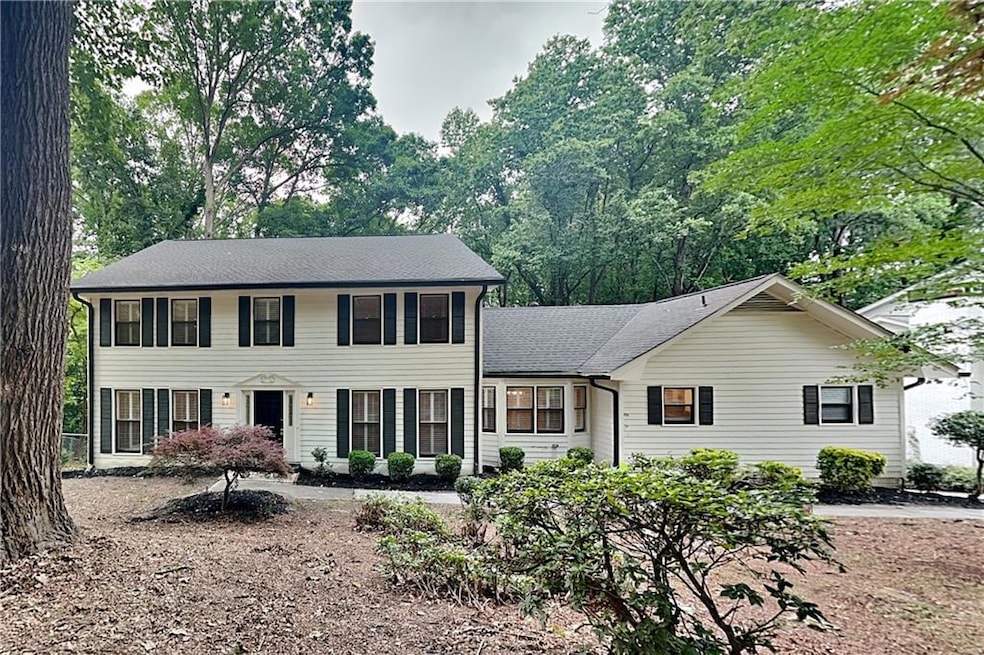 Colonial home featuring a shingled roof