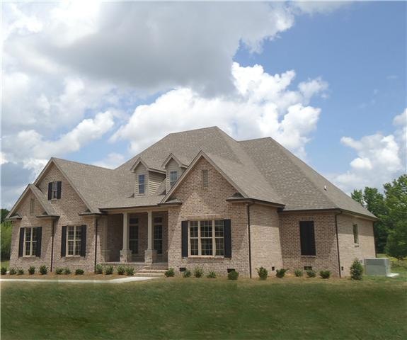 This beautiful new house in Wellington feautres columns with stone pillars on the front porch and sets on a custom landscaped lawn that has been well nourished.