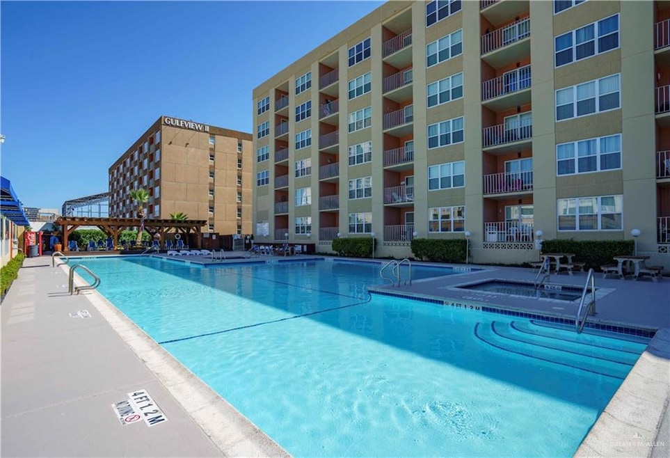 View of pool with a hot tub