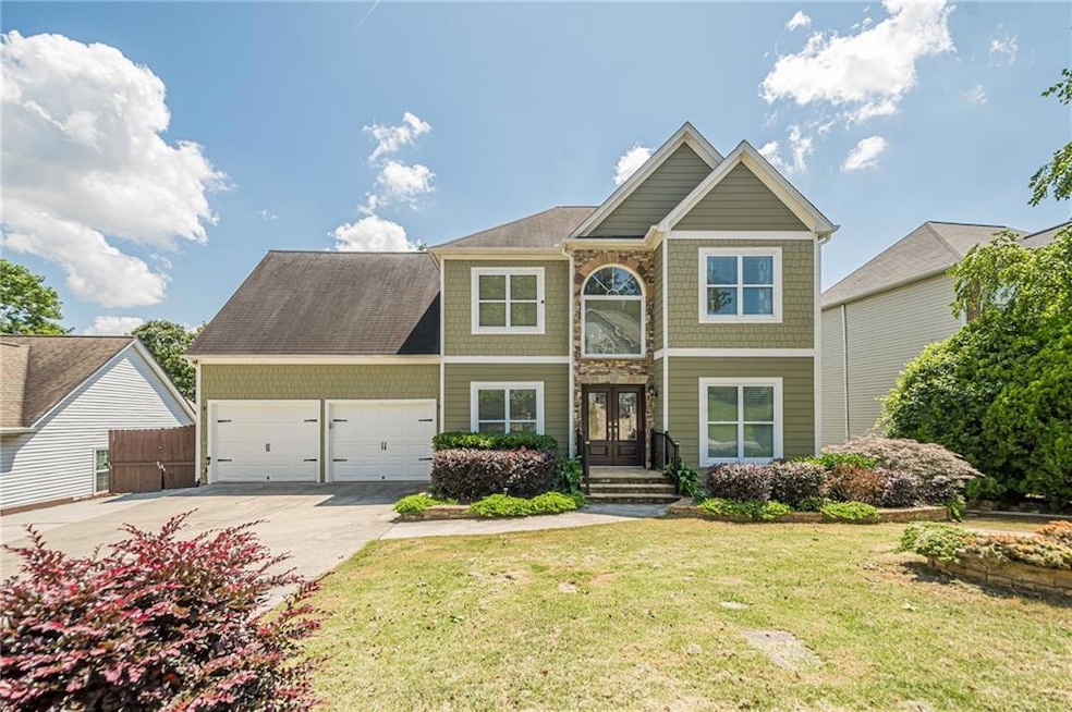 View of front of house featuring driveway, a garage, and french doors