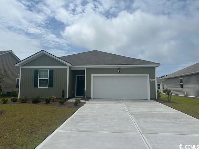 Single story home featuring driveway, an attached garage, and a front yard