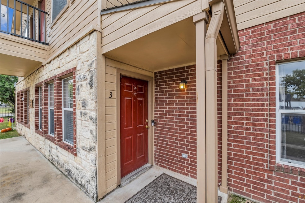 Entrance to property with brick siding and a porch