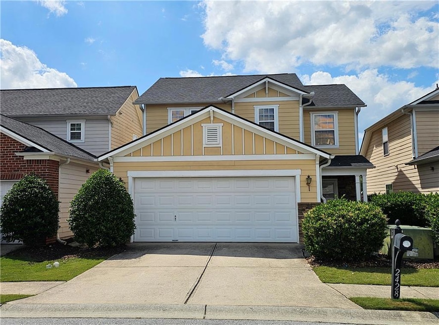 View of front of home with board and batten siding, concrete driveway, an attached garage, and a shingled roof