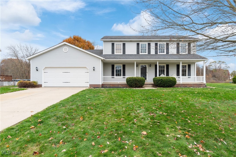 View of front facade featuring a porch, concrete driveway, an attached garage, a front lawn, and a shingled roof